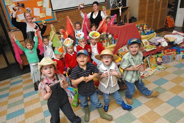 RETRO 2007 - Infants at Sacred Heart Catholic Primary School, Springfield, put on a song and dance at their harvest festival celebration, organised by Key Stage One manager Geraldine McAdam, left, at which the food, toys and clothes collected were handed over to Cherry Williams, refuge manager of Wigan Women's Aid, right.