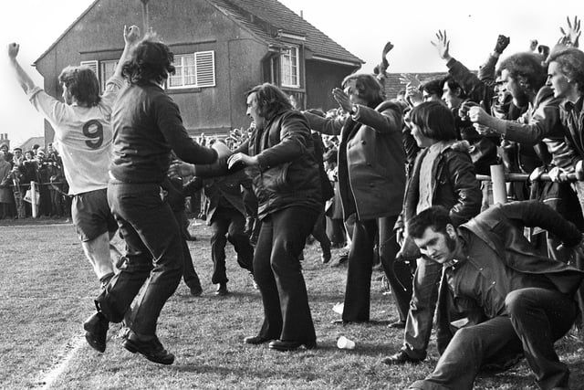 Wigan Athletic forward John Rogers celebrates with fans after scoring the opening goal against Lancaster City at Giant Axe in the FA Trophy 3rd round match on Saturday 22nd of February 1975. Latics won the game 2-0 with Mickey Worswick scoring the other goal.
