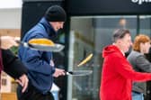 Ferocious concentration as competitiors speed-walk while continuously tossing their pancakes