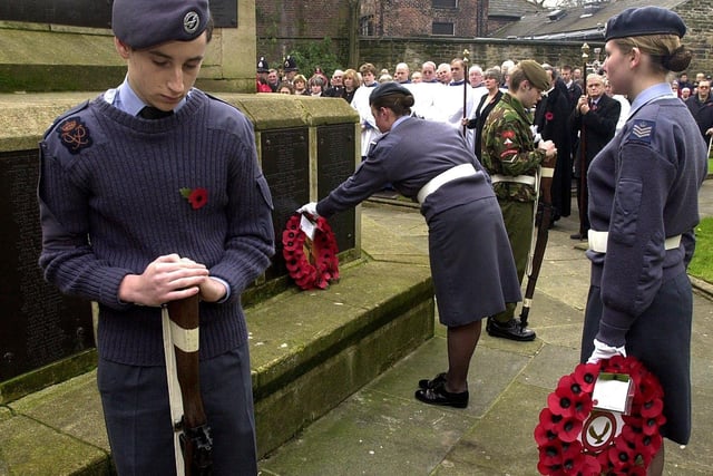 RETRO 2004 
Tom Coulson stands guard as Amy Burrows, right, and Rhian Pritchard, centre, 723(Wigan) Air CAdet Squadron Training Corps lay wreaths at Wigan's remembrance Day Service.