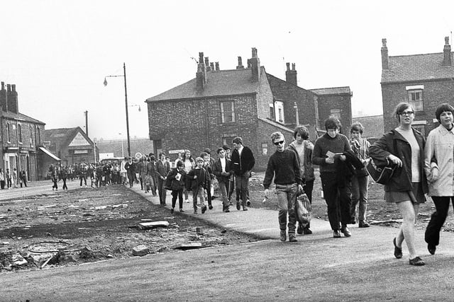 Youngsters taking part in the round the beacons charity walk in May 1969. I took part myself in the walk which was 24 miles long and involved hiking around Billinge beacon to Ashurst beacon and Parbold beacon back to Wigan Rugby Union Club via Standish.  This section is on Ormskirk Road, Newtown, with the Bird i'th Hand pub on the left and Douglas Garage in the background. On the right is Trentham Street.