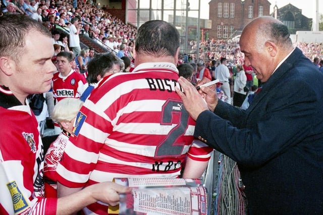 Wigan rugby league legend Billy Boston signs a shirt for a fan, before the kick off against St. Helens.