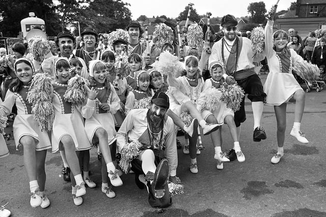 Keeping in step are morris dancers of different codes with the Platt Bridge Debutantes and the Horwich Prize Medal Morris Men at Wigan Infirmary garden party on Saturday 18th of August 1979.