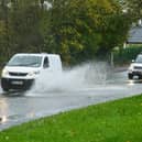 Vehicles drive through flooding on Wigan Lower Road in November 2021