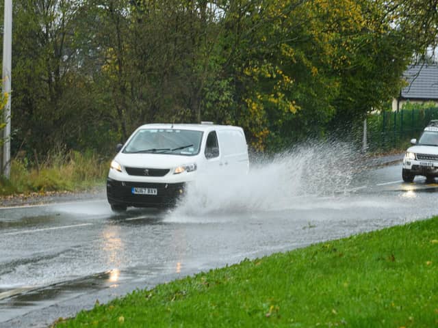 Vehicles drive through flooding on Wigan Lower Road in November 2021