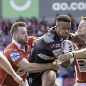 St Helens's Regan Grace is wrapped up by Salford's Alex Gerrard & Deon Cross in Round 21 of the 2022 season