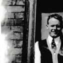 Ted in front of the ill-fitting and unpainted front door of the family home in Miry Lane