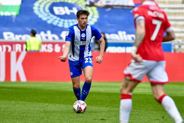 James Carragher looks to pick a pass against Wrexham