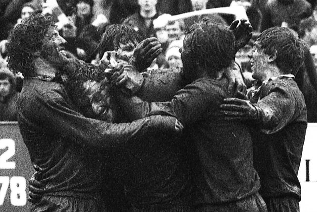 Mud caked Wigan players celebrate after beating St. Helens 16-7 in the Challenge Cup quarter-final at Knowsley Road on Sunday 11th of March 1984.