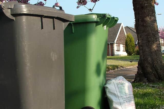 Refuse collection day in Wigan with garden waste bins and recycle sacks.