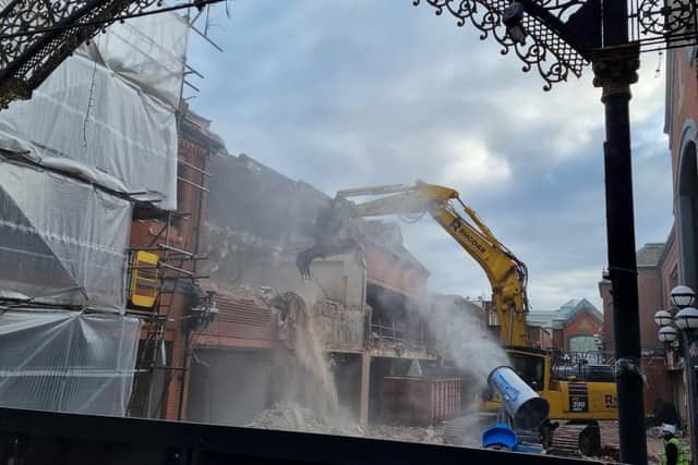 A digger tears at the familiar red brick surrounds of the Galleries