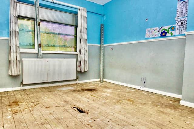 A spacious room in need of redecorating - and the floor repairing