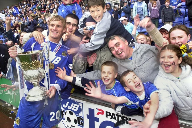 Gary Teale shares the moment with the fans as Wigan Athletic lift the Division 2 championship trophy after beating Barnsley 1-0 with a Tony Dinning goal on Saturday 3rd of May, the last day of the 2002/2003 season. 