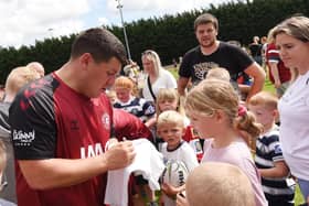 Matty Peet takes the time to sign some autographs at Wigan Warriors' open training session