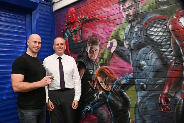 Artist Scott Wilcock, also known as Snow Graffiti, working on a surprise Marvel mural for junior pupils at St John's CE Primary School, Pemberton.  Pictured with headteacher Mark Speakman, right.