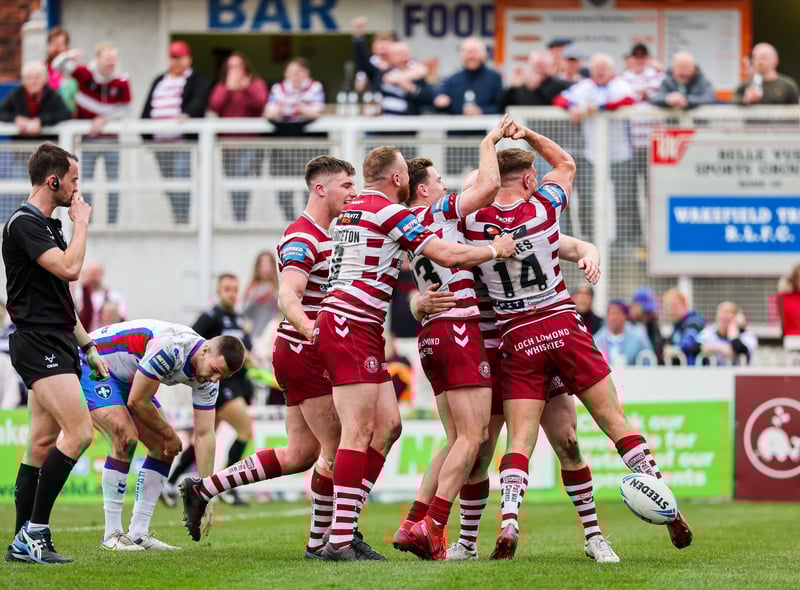 Liam Farrell celebrates his try with the rest of his Wigan teammates