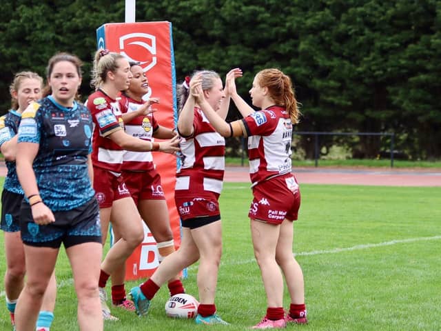 Grace Banks (right) celebrates try for Wigan Warriors Women against Leigh Leopards with teammate Rachel Thompson (left)