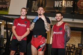 UFC Heavyweight Tom Aspinall, centre, with Wigan Warriors players Morgan Smithies, left, and Cade Cust, right.