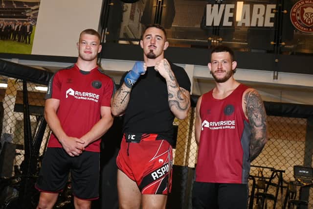UFC Heavyweight Tom Aspinall, centre, with Wigan Warriors players Morgan Smithies, left, and Cade Cust, right.
