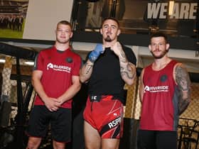 UFC Heavyweight Tom Aspinall, centre, with Wigan Warriors players Morgan Smithies, left, and Cade Cust, right.