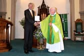 Phil Livesey receives his Benemerenti Medal from Fr Kevin
