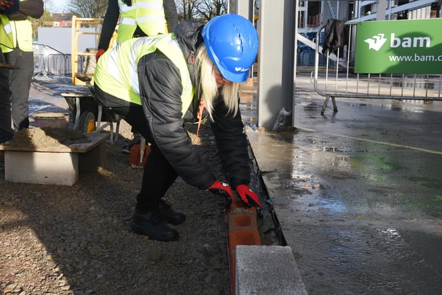 Long-serving staff member, Anita Mollineaux, lays a brick  to mark the progress of the new school building at Fred Longworth High School, Tyldesley.