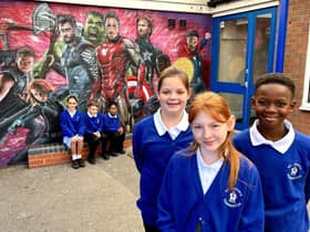 Pupils at St Johns CE Primary School with the superhero mural