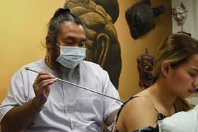 Skin Graffiti Tattoo Studio, Wigan, hosts Ajarn Ohr, a Sak Yant Master from Thailand, using traditional methods to create tattoos and blesses them.
