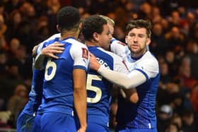 Tom Naylor is mobbed after opening the scoring for Latics