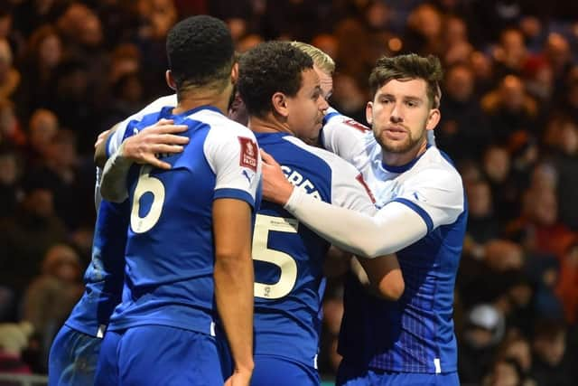 Tom Naylor is mobbed after opening the scoring for Latics