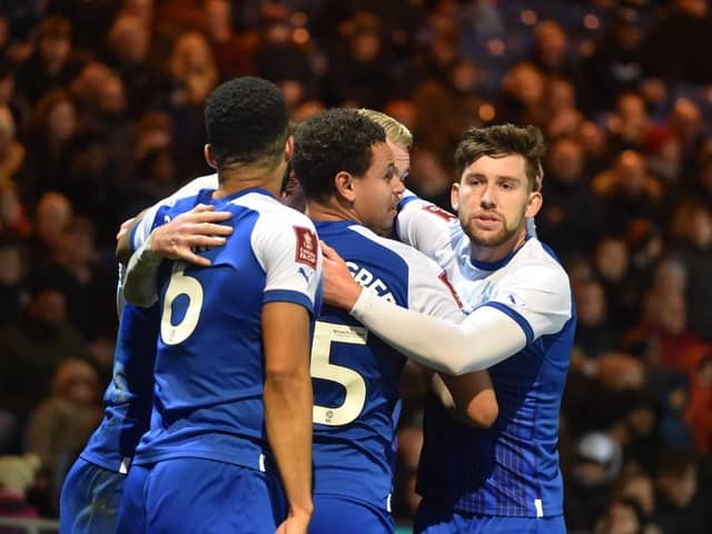 Tom Naylor is mobbed after opening the scoring for Latics