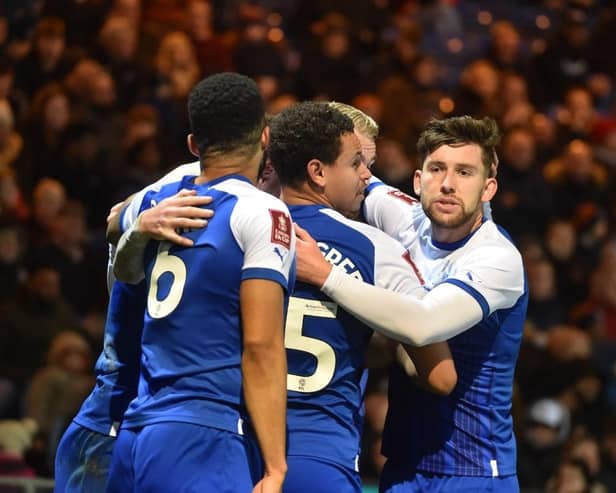 Tom Naylor is mobbed after opening the scoring for Latics