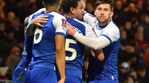 Tom Naylor is mobbed after opening the scoring for Latics