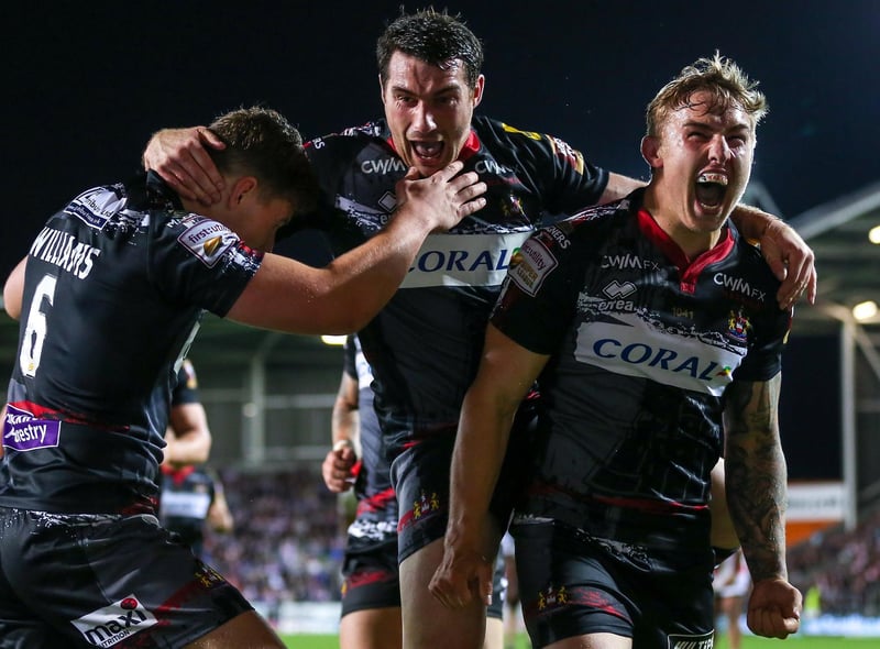 Powell celebrates with Matty Smith and George Williams after the latter's try against St Helens.