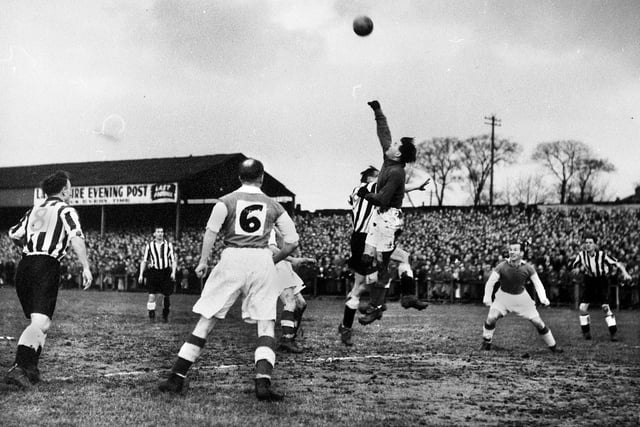 Wigan Athletic goalkeeper Bert Lomas punches clear from a Newcastle attack.