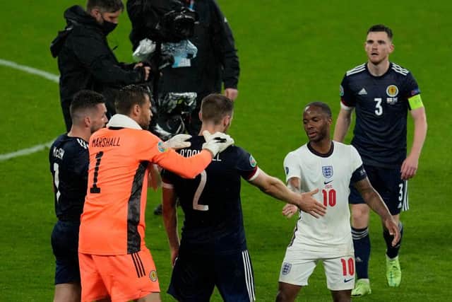 Scotland's defender Stephen O'Donnell shakes hands with England's forward Raheem Sterling after the Group D draw between England and Scotland at Wembley Stadium.