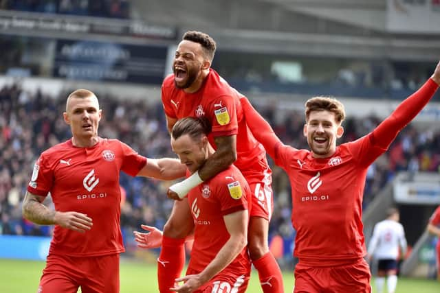 The Latics players celebrate the demolition derby at Bolton