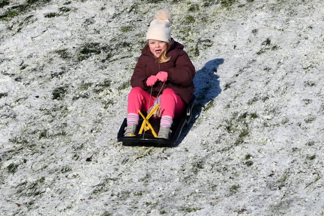 Wigan snow scenes - People make the most of the winter weather as snow falls on Mesnes Park, Wigan.