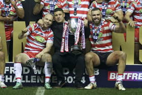 Wigan Warriors head coach Matt Peet celebrates with the trophy and players at the end of the match