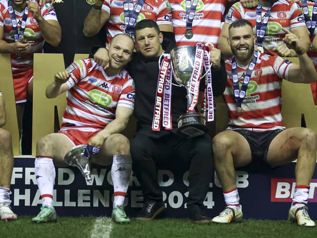 Wigan Warriors head coach Matt Peet celebrates with the trophy and players at the end of the match