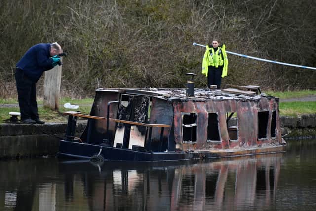 Fire and police investigators inspect the burnt out canal boat near to Dover Lock, Abram