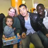 Wigan Athletic players deliver Christmas presents on Rainbow Ward at Wigan Infirmary. Patient Elliott with Joanne Brown and players Antonio  Amaya, Won Hee Cho and Momo Diame