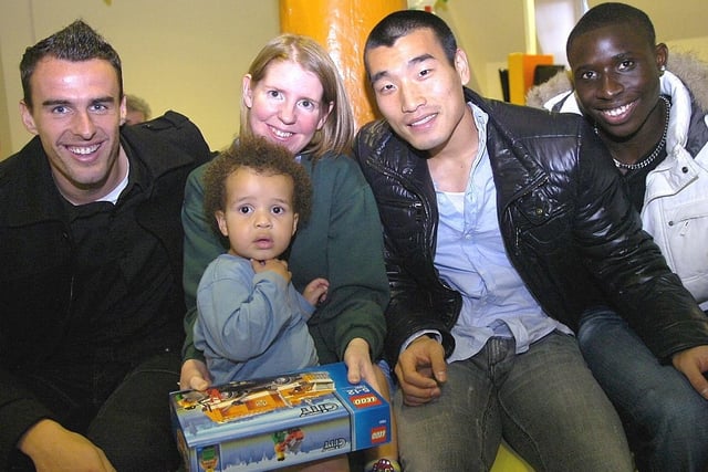Wigan Athletic players deliver Christmas presents on Rainbow Ward at Wigan Infirmary. Patient Elliott with Joanne Brown and players Antonio  Amaya, Won Hee Cho and Momo Diame