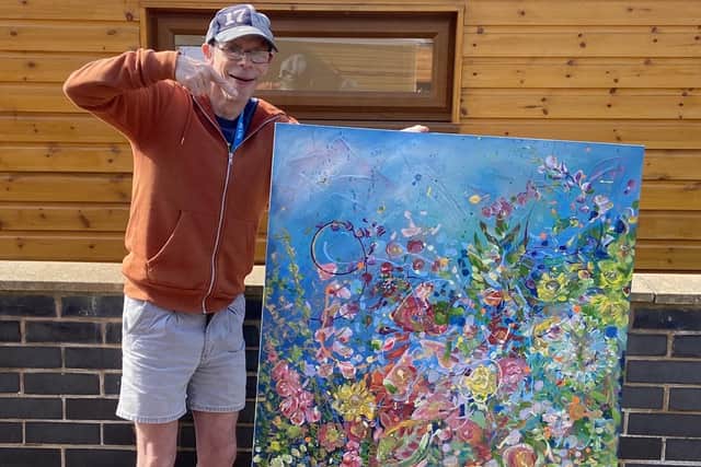 Michael Atherton with the collaborative art piece which he worked on called, Colourful Journey.