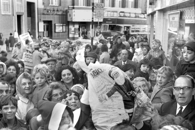 Father Christmas is swamped as he arrives at Oxleys store on Station Road, Wigan, in 1971.