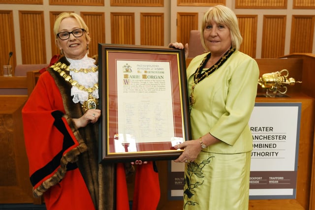 Outgoing Mayor of Wigan Coun Yvonne Klieve, left, gets ready to pass on her chains as she welcome the new Mayor of Wigan Coun Marie Morgan, right.