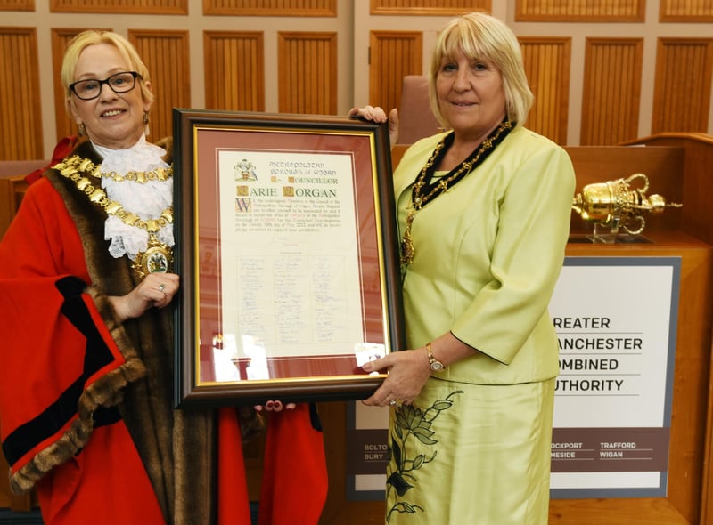 Outgoing Mayor of Wigan Coun Yvonne Klieve, left, gets ready to pass on her chains as she welcome the new Mayor of Wigan Coun Marie Morgan, right.