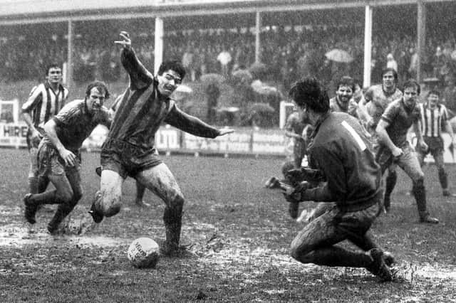 The ball sticks in the mud for Wigan Athletic striker Mick Quinn in the Division 4 match against Torquay United at a flooded Springfield Park on Saturday 21st of March 1981.
Latics won the game 2-0 with goals from Bob Hutchinson and an own goal.