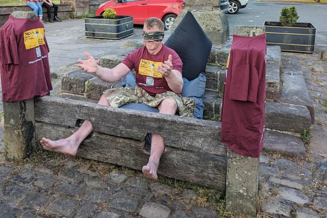 Nigel Brookwell spending the night in the stocks in Standish as part of his charity challenge, raising funds for Wigan-based Empathy North West CIC