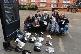 Children and parents leave shoes outside Wigan Life Centre in the Every Pair Tells a Story movement
